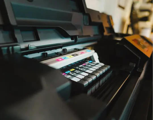Close-up of a digital printer with CMYK ink cartridges